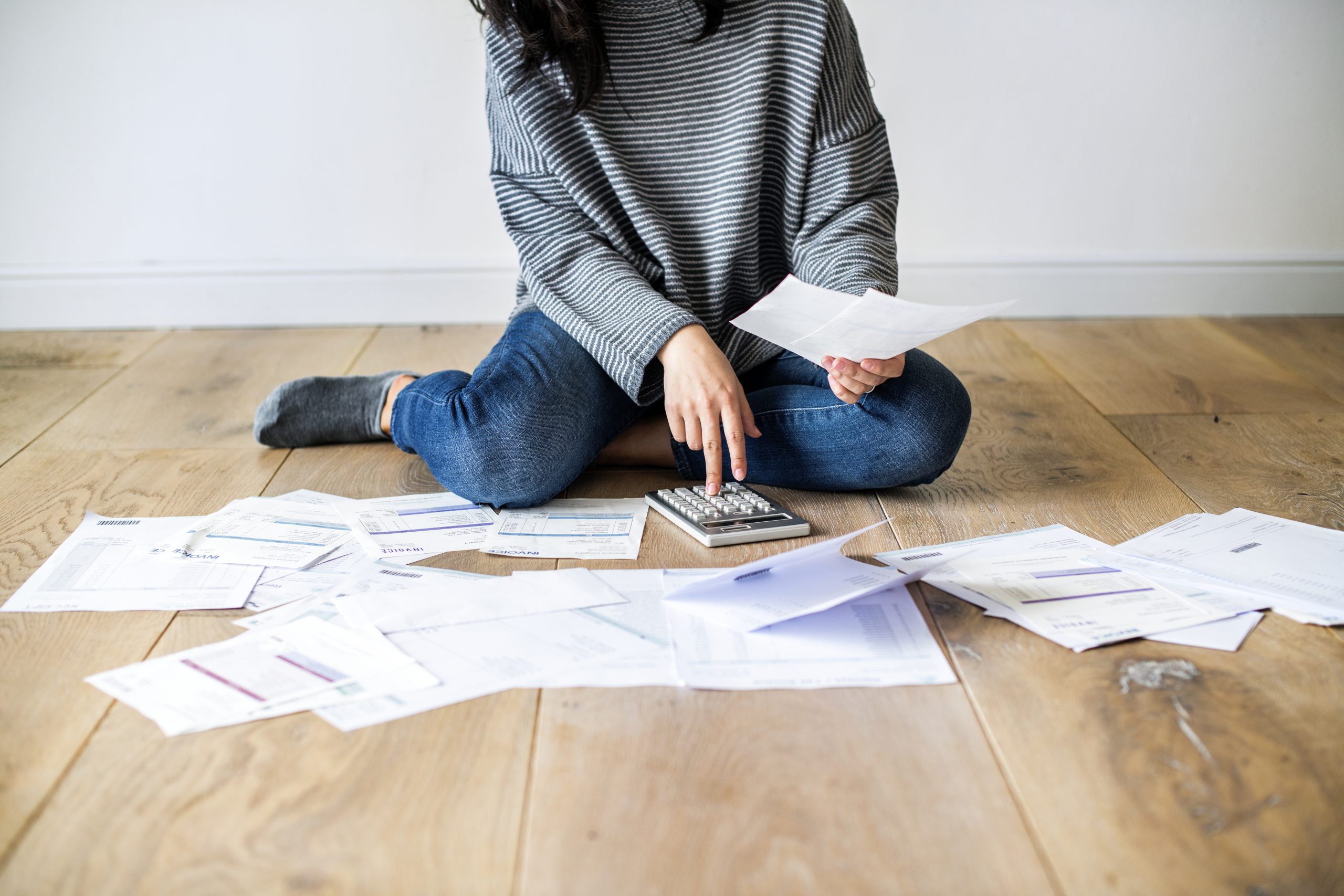 woman-managing-the-debt-2025-02-10-12-02-00-utc woman sitting with paperwork